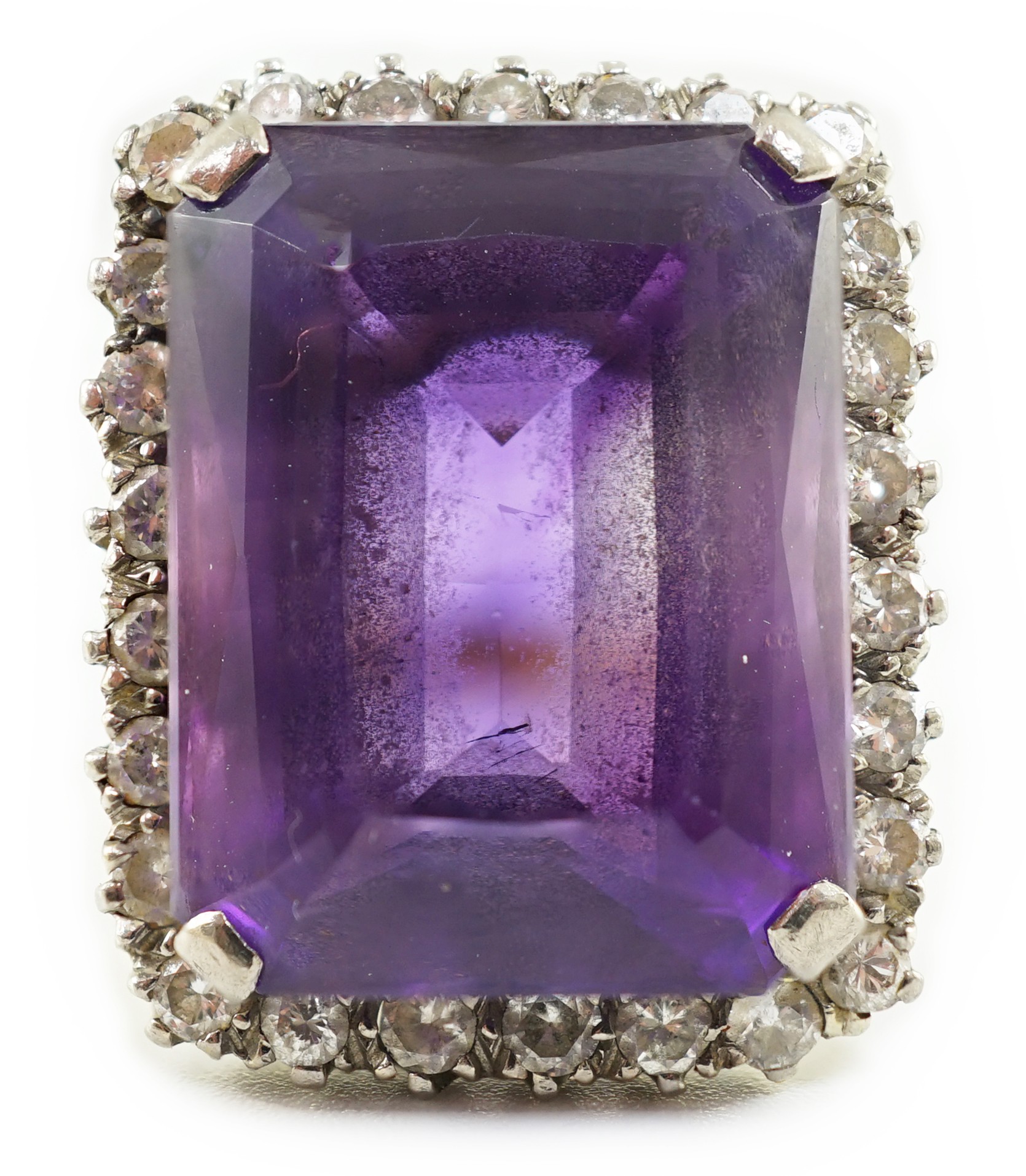 A large modern 18ct gold and emerald cut amethyst set dress ring, with diamond set border